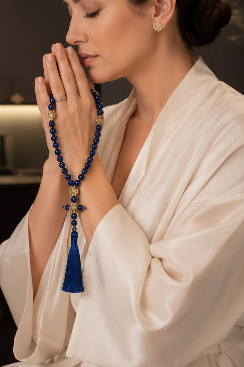 Blue prayer beads held in prayer