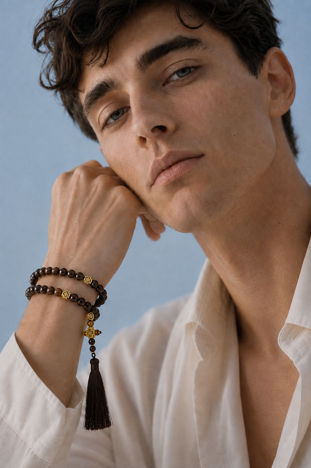 Brown prayer beads wrapped twice around a man's wrist, fashion portrait