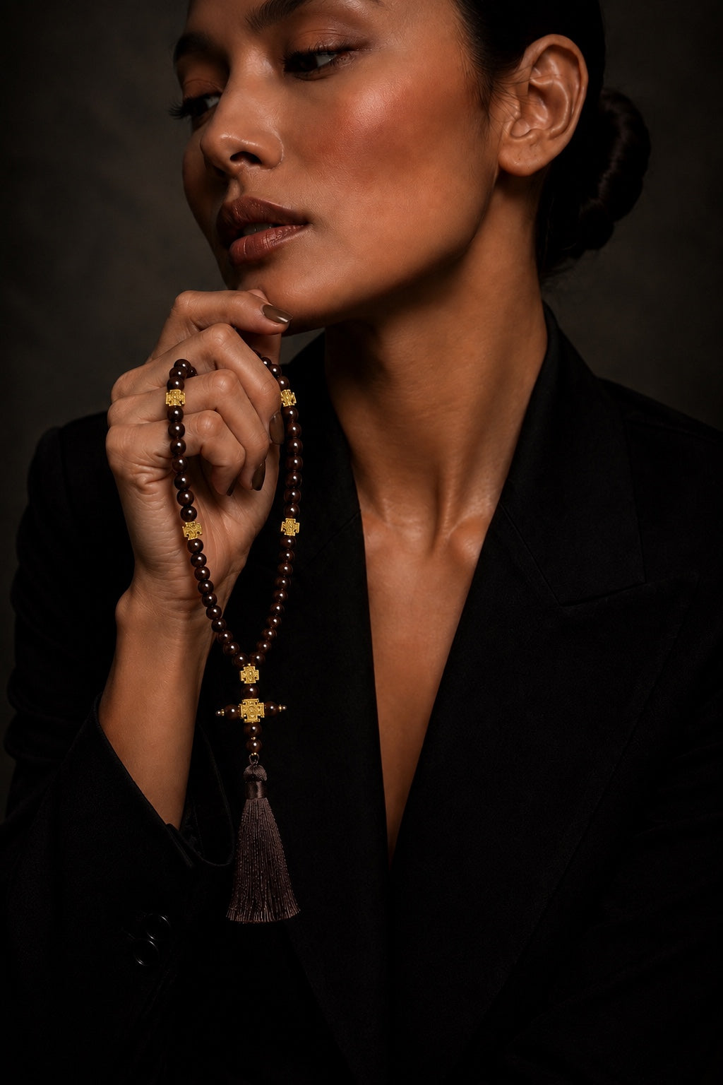 Woman holding brown 50-bead prayer beads, fashion portrait