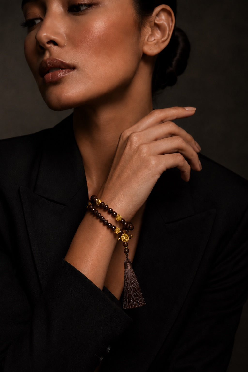 Woman wearing brown 50-bead prayer beads, fashion portrait